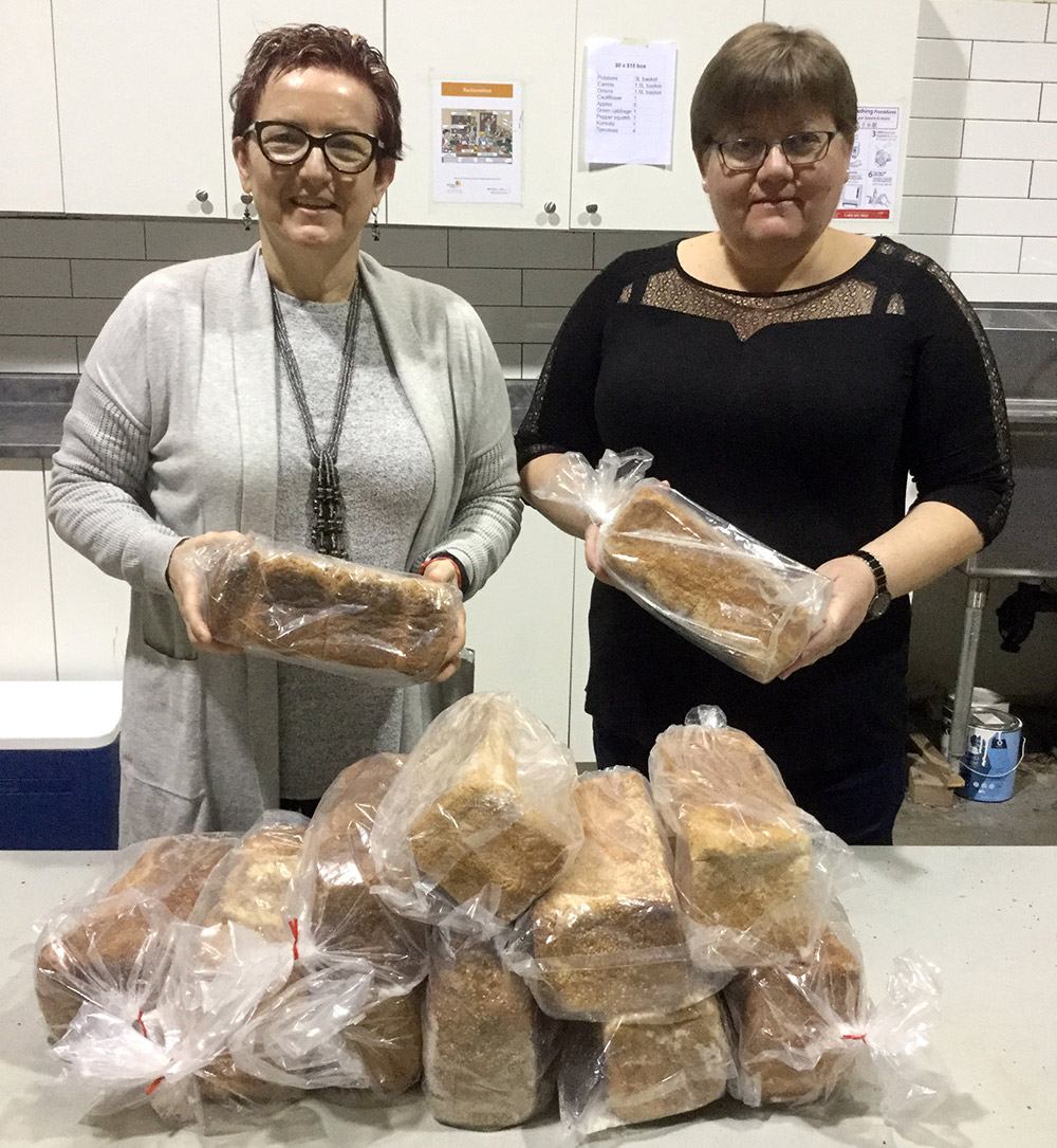 Professor McInnis and Donciu holding loaves of bread